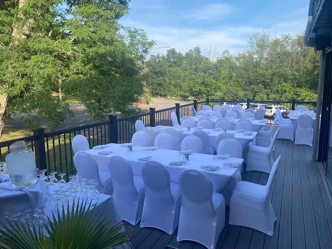 The Mansard deck set with white linens and chairs for a full-service catered event