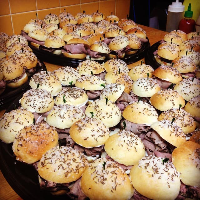 Trays of beef on weck sliders prepared by The Mansard for catering