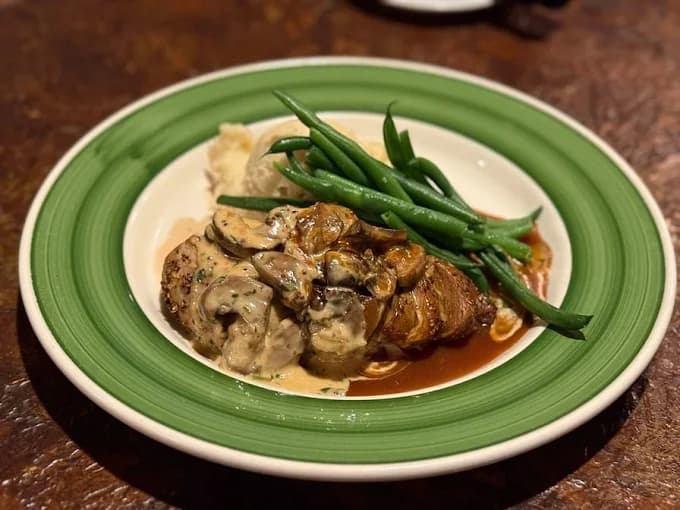 Pan-seared almond-crusted Chicken a la Mansard plated with mashed potatoes and green beans