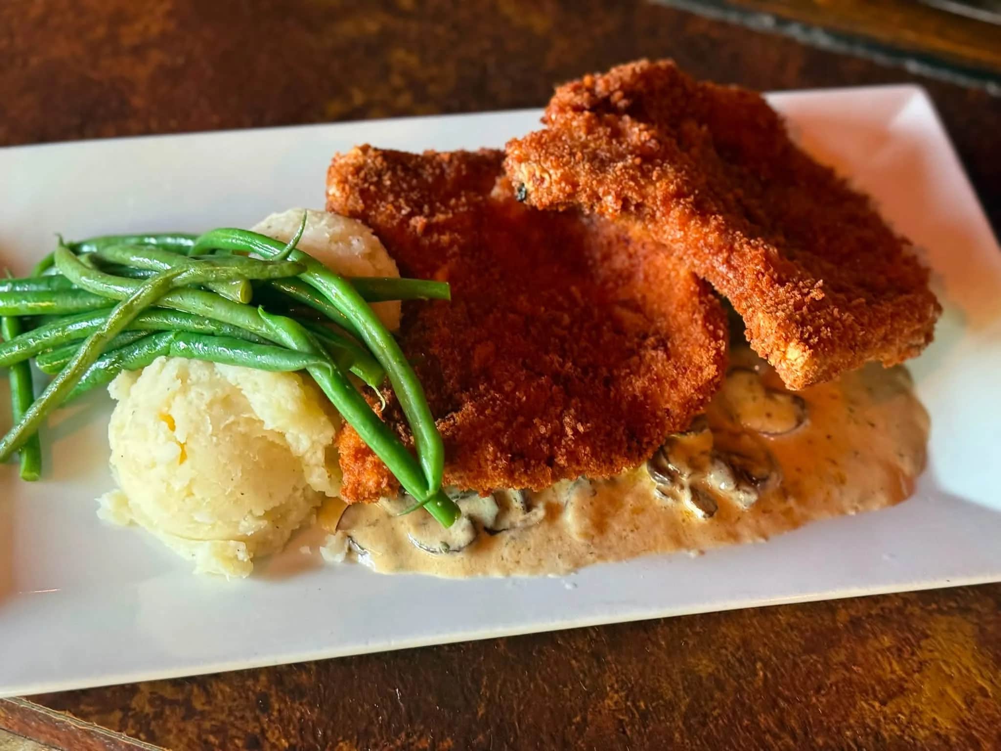 Panko-crusted pork chops over creamed cremini mushrooms with haricot vert and whipped potatoes at The Mansard