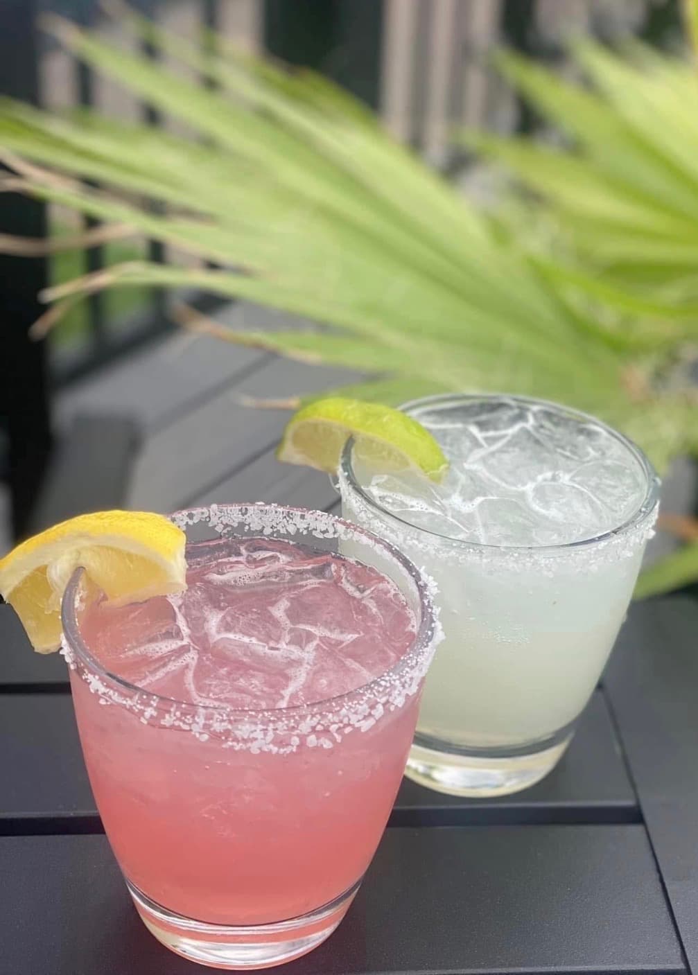 Two freshly poured margaritas with salt rims and citrus garnish, served on the deck at The Mansard in Orchard Park, NY