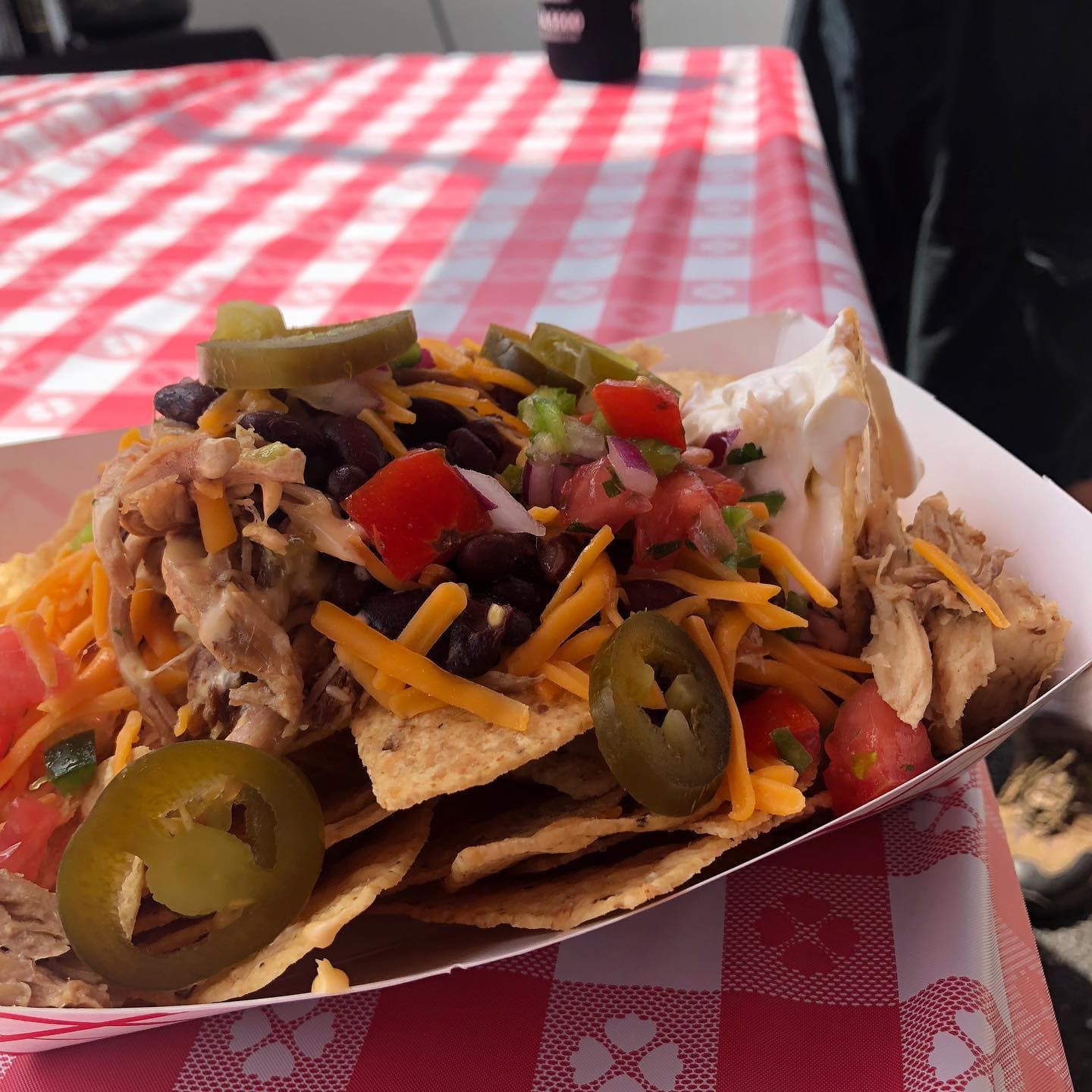 Loaded gameday nachos with pulled chicken, black beans, jalapeños, and sour cream at a Mansard Bills tailgate